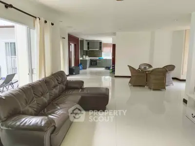 Spacious open-plan living room with modern kitchen and elegant furnishings.