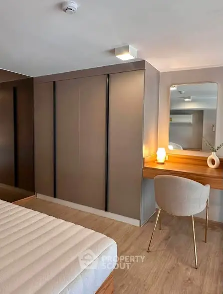 Modern bedroom with sleek wardrobe and stylish vanity area, perfect for contemporary living.