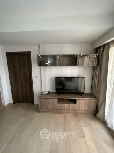 Modern living room with sleek wooden TV unit and natural light