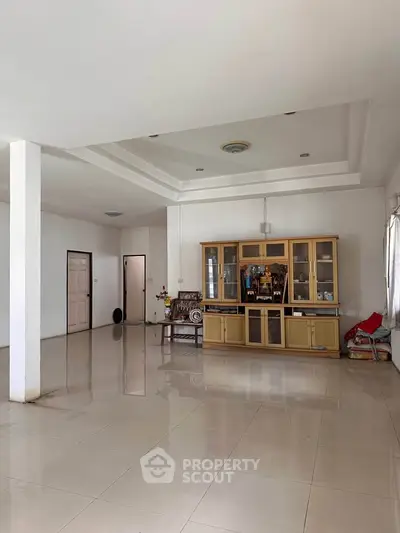 Spacious living room with elegant ceiling design and ample natural light.