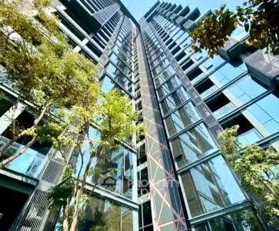 Stunning modern high-rise building with glass facade and lush greenery