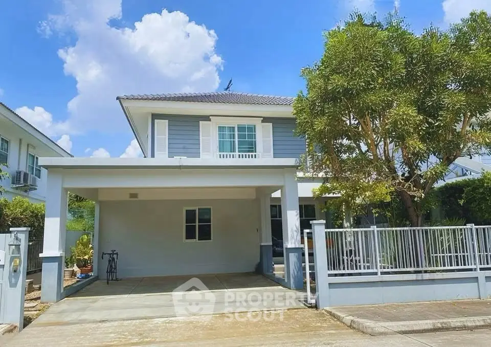Charming two-story house with spacious driveway and lush greenery, perfect for family living.
