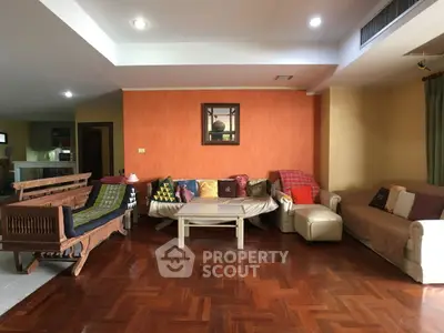 Spacious living room with cozy seating and warm wooden flooring