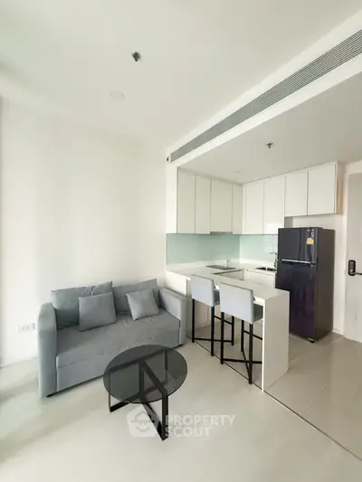 Modern open-layout living room with sleek kitchen and stylish furniture