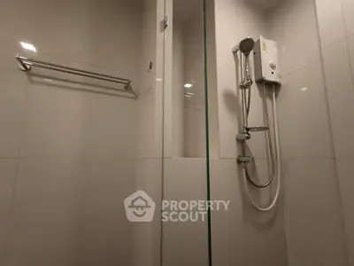 Modern bathroom with sleek shower and white tiles, perfect for a contemporary home.