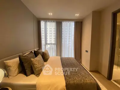 Luxurious bedroom with elegant decor and large windows offering natural light.