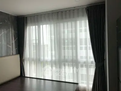 Modern bedroom with large window and elegant curtains in a high-rise apartment.