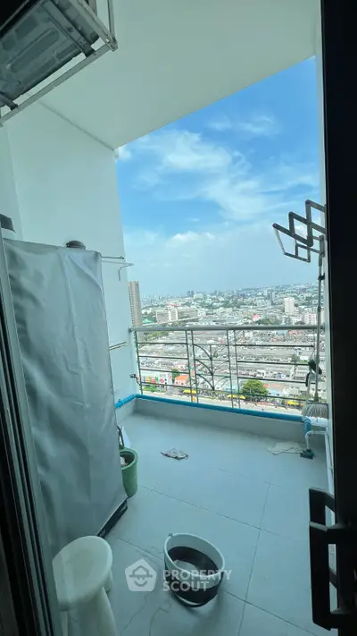 High-rise balcony with stunning cityscape view and laundry area.