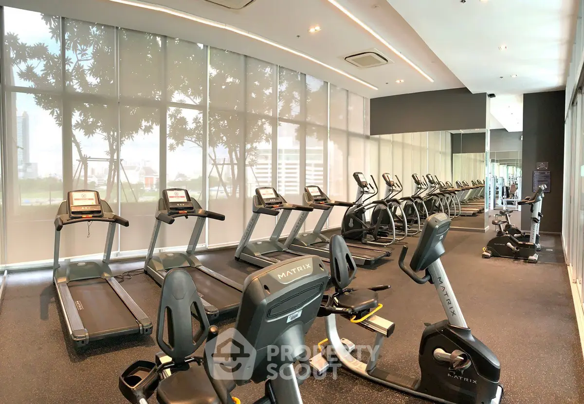 Modern gym with state-of-the-art equipment and city view windows.