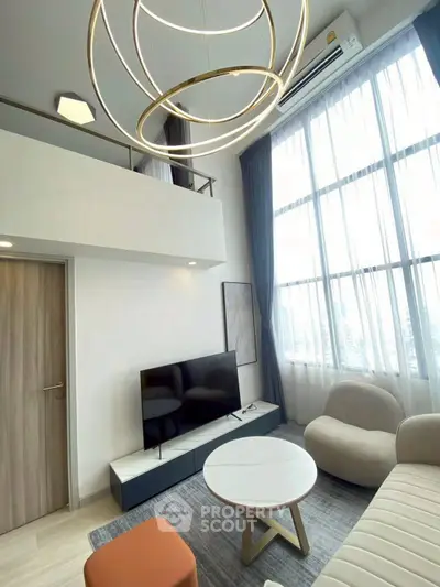 Modern living room with high ceilings, stylish chandelier, and large windows offering natural light.