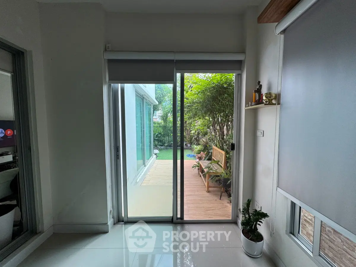 Bright interior with sliding doors opening to a lush garden patio, perfect for relaxation.