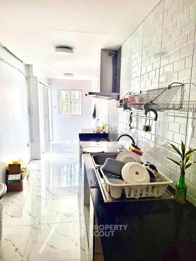 Modern kitchen with sleek black countertops and white tile backsplash