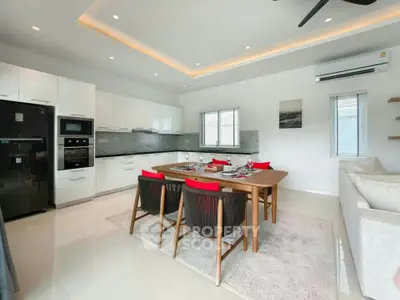 Modern open-layout kitchen and dining area with sleek appliances and stylish decor.