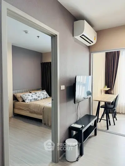 Modern apartment interior with cozy bedroom and stylish living area, featuring air conditioning and natural light.