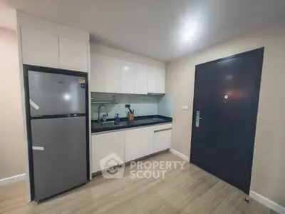 Modern kitchen with sleek cabinetry and stainless steel appliances in a contemporary apartment.