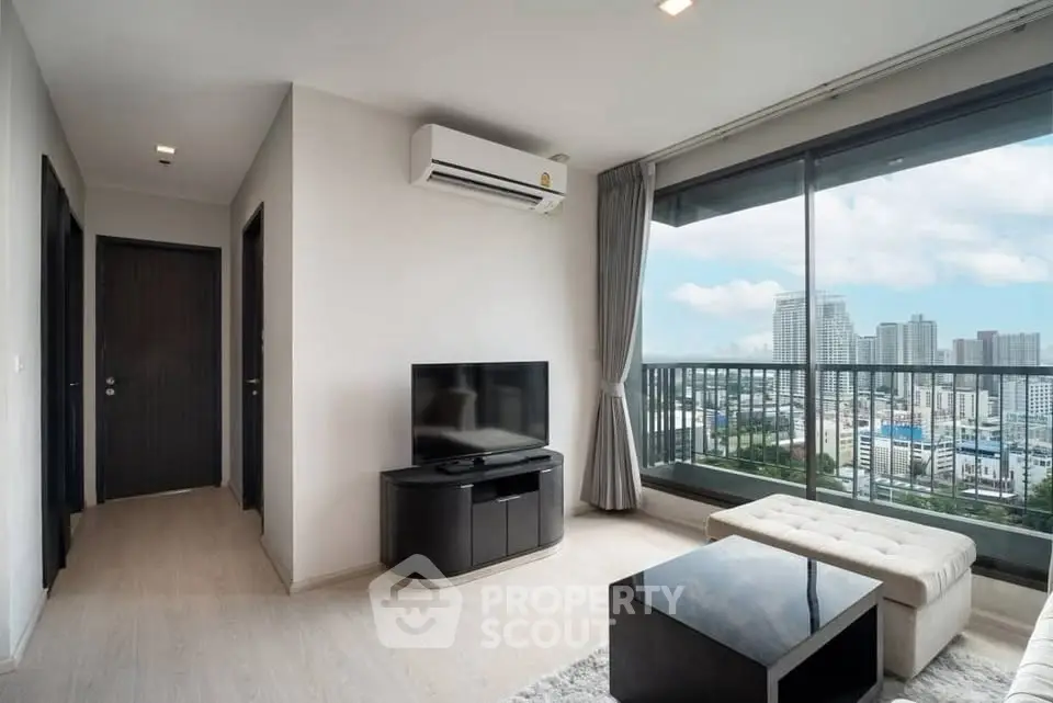 Modern living room with city view and sleek furniture in high-rise apartment.