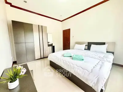 Spacious bedroom with modern furniture and elegant decor in a bright, inviting setting.