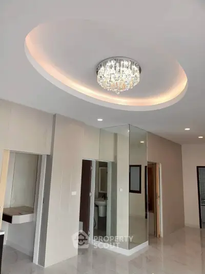 Elegant modern interior with chandelier and mirrored wall in a stylish living space.