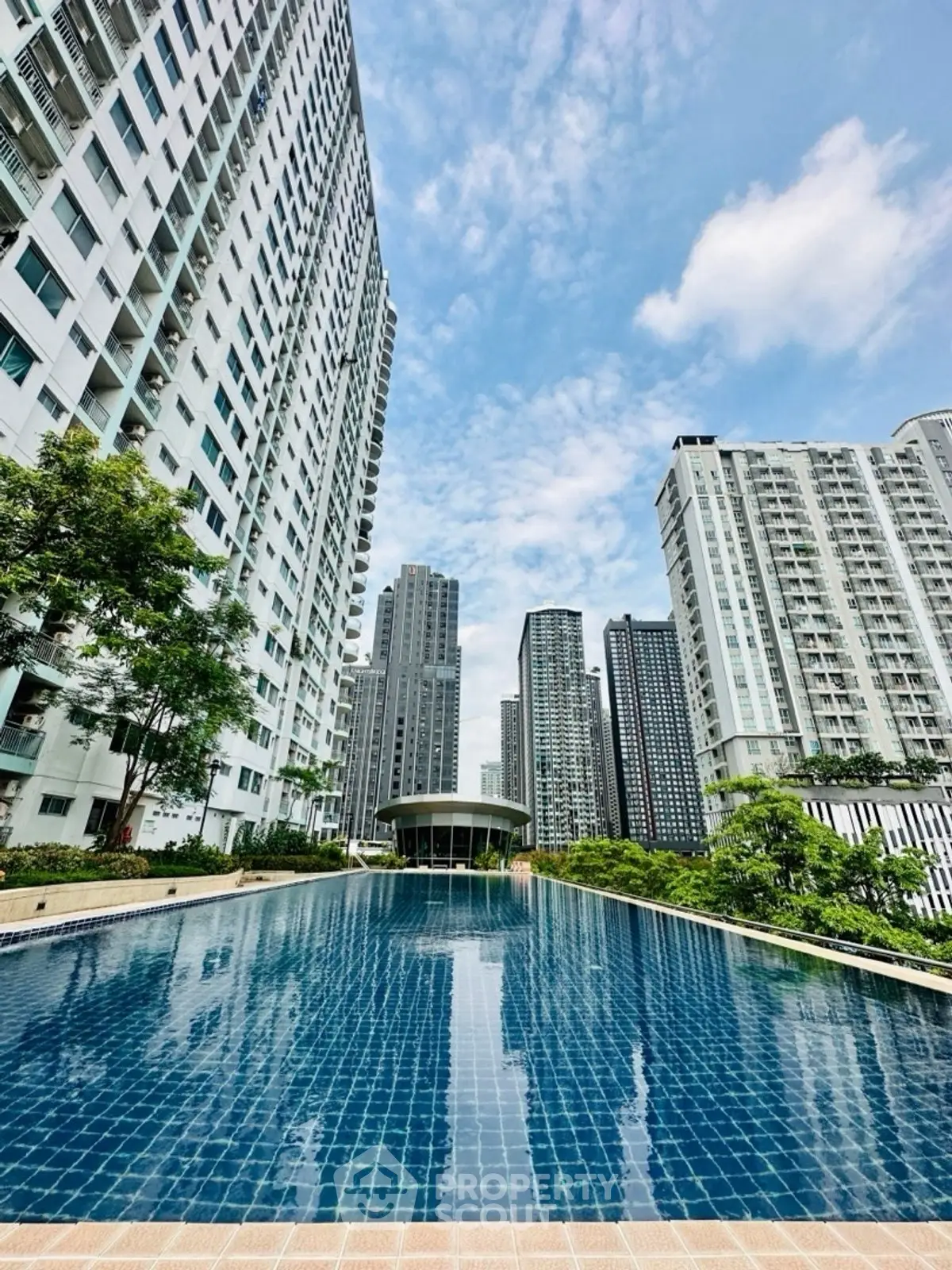Luxurious high-rise apartment complex with stunning pool and skyline views.