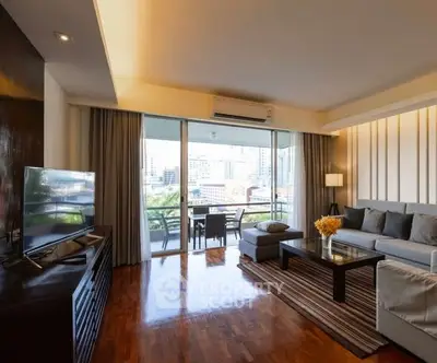 Spacious living room with modern decor and city view balcony access.