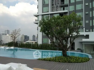 Luxurious modern apartment building with rooftop pool and city skyline view.