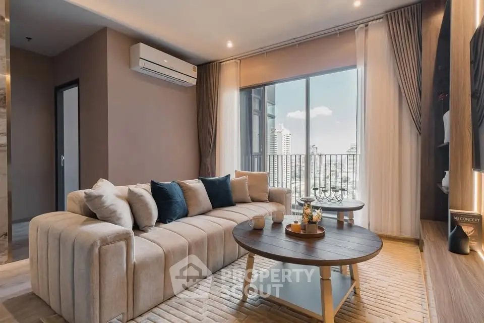 Luxurious living room with modern decor and city view balcony in high-rise apartment.