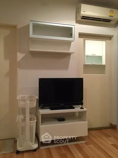 Modern living room with sleek TV stand and air conditioning unit, showcasing minimalist design.