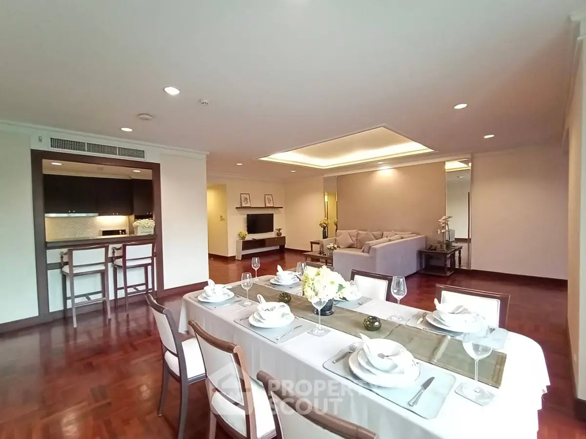 Spacious open-plan living and dining area with elegant decor and hardwood floors