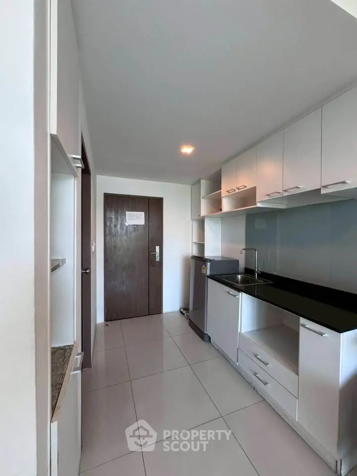 Modern kitchen with sleek cabinetry and stainless steel appliances in a contemporary apartment.