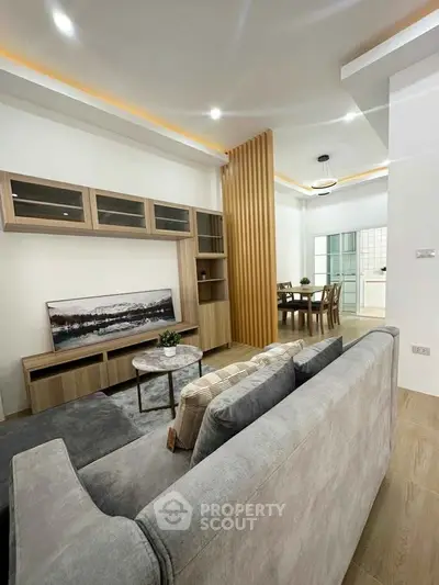 Modern living room with stylish decor and open layout leading to dining area.