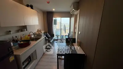 Modern compact kitchen and living area with city view in high-rise apartment