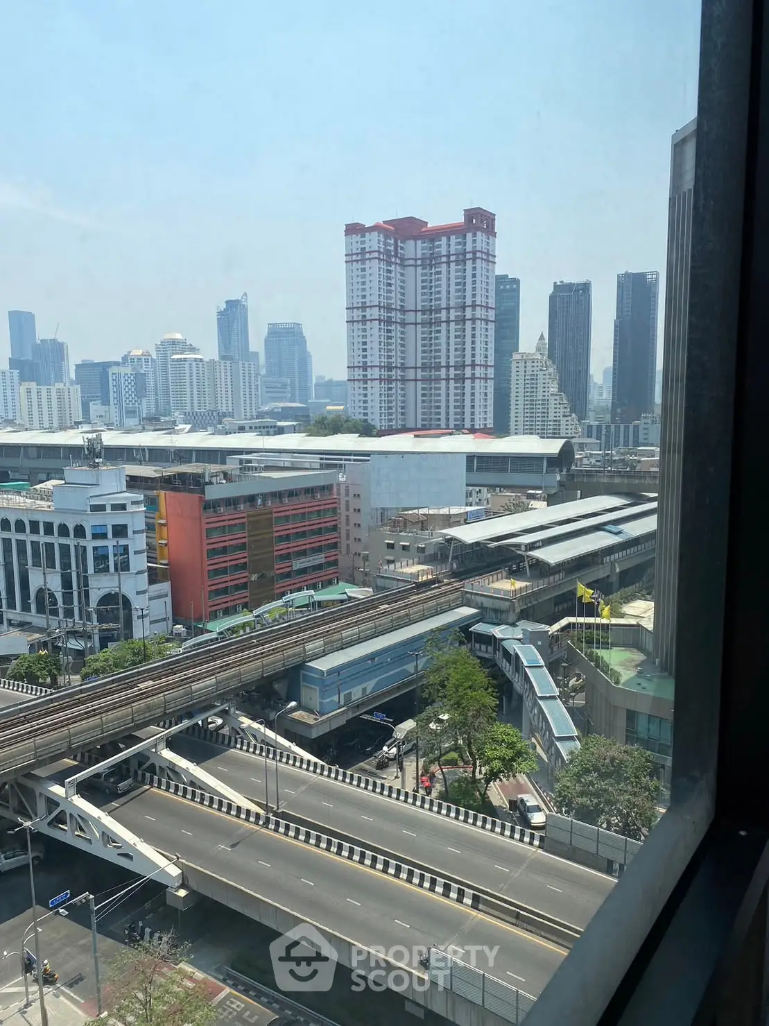 Stunning cityscape view from high-rise building window showcasing urban skyline and infrastructure.