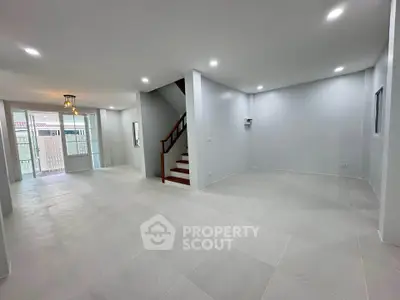 Spacious modern living room with open layout and staircase, perfect for family gatherings.