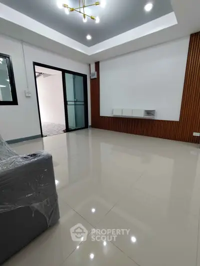 Spacious modern living room with sleek design and glossy tiled flooring.