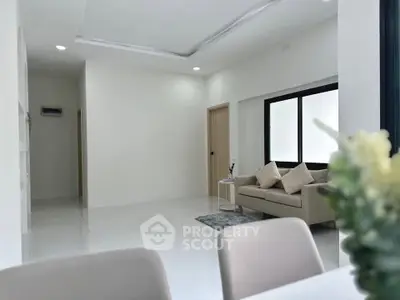 Modern minimalist living room with neutral tones and cozy seating area.
