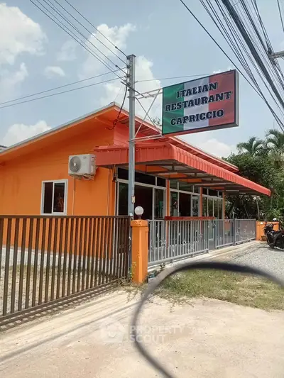 Charming Italian restaurant with vibrant orange exterior and inviting entrance.