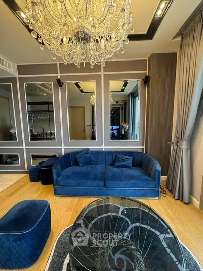 Luxurious living room with elegant chandelier and plush blue sofa