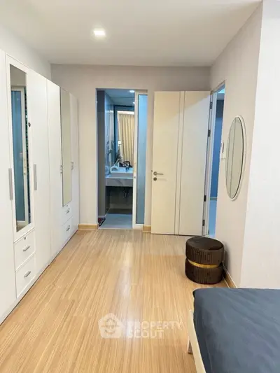 Modern bedroom with ensuite bathroom and sleek wooden flooring