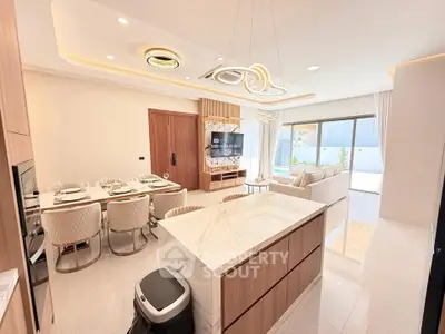 Luxurious open-plan living room with modern kitchen and elegant dining area, featuring stylish lighting and large windows.
