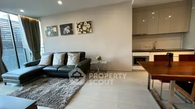 Modern living room with sleek kitchen, cozy sofa, and elegant decor