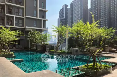 Luxurious urban apartment complex with stunning pool and lush greenery, perfect for modern living.