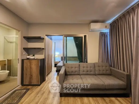 Modern living room with stylish sofa and wooden flooring in a cozy apartment setting.