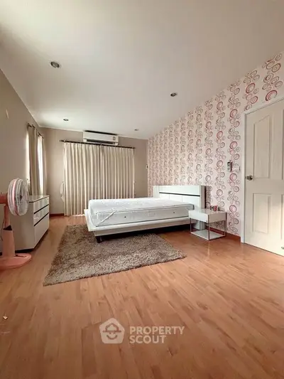 Spacious bedroom with modern decor and wooden flooring