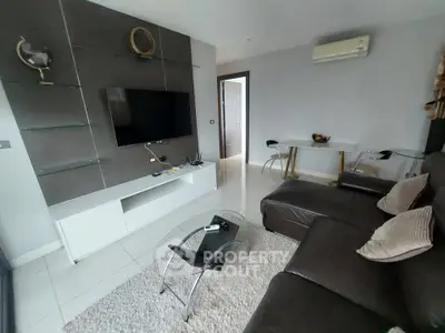Modern living room with sleek furniture and wall-mounted TV in a stylish apartment.