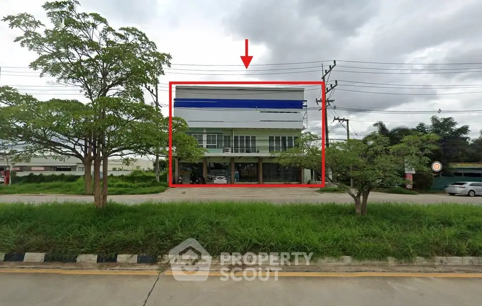 Modern commercial building with glass facade and ample parking space, ideal for businesses seeking visibility.