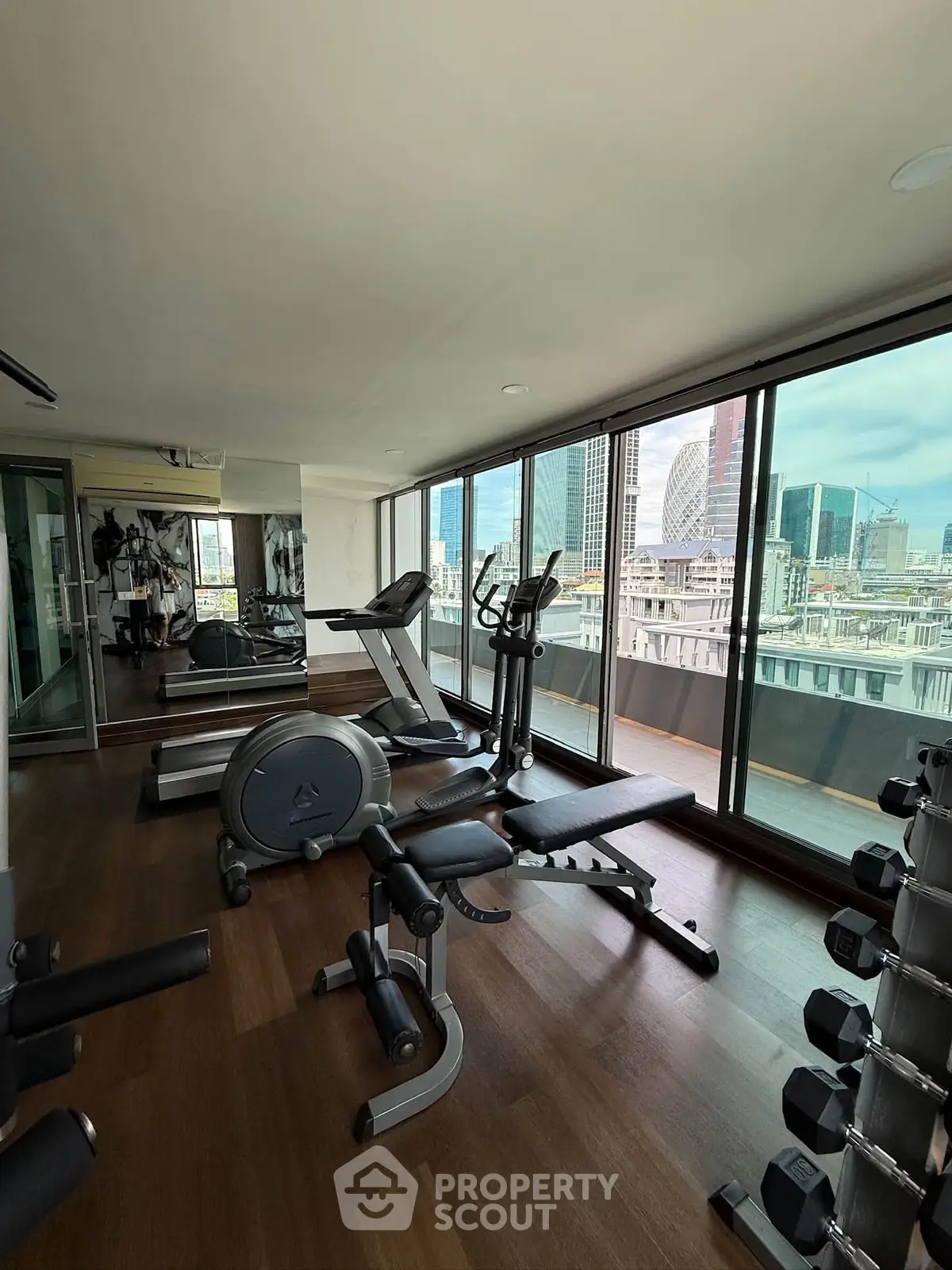 Luxurious high-rise gym with panoramic city views and modern fitness equipment.