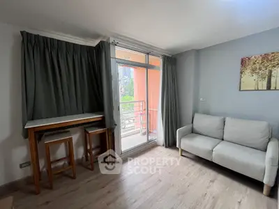 Cozy living room with balcony access and modern furniture in a stylish apartment.