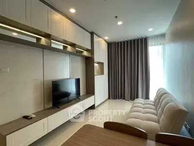 Modern living room with sleek cabinetry and cozy seating in a bright apartment.