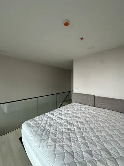 Modern bedroom with minimalist design and large bed in a loft-style apartment.