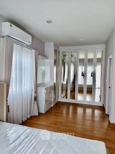 Spacious bedroom with mirrored wardrobe and natural light